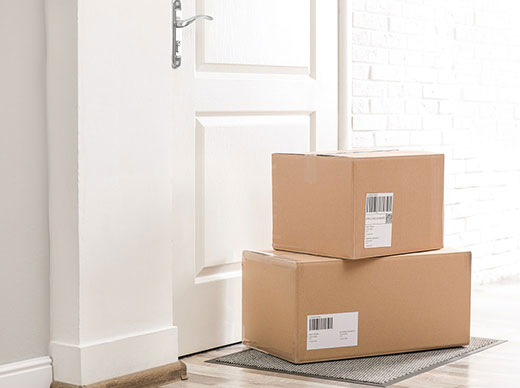 shipping boxes stacked outside a white paneled door