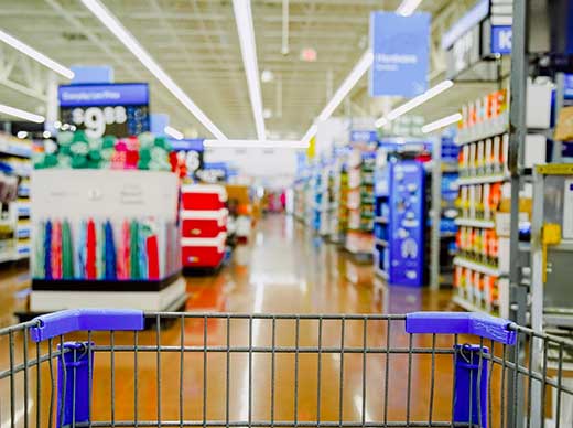 shallow focus view of store ailes infront of a shopping cart