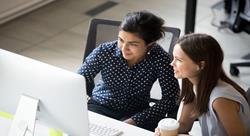 female colleagues looking at laptop screen