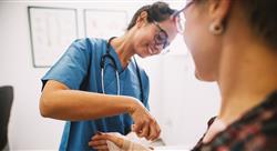 Professional nurse at the hospital bandaging the hand with a medical bandage for a woman patient.