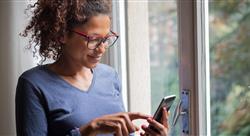 woman smiling near window reading phone message