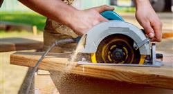 Builder saws a board with a circular saw cutting a wooden plank