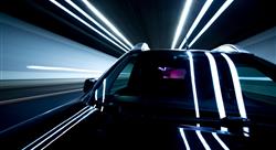 close-up of black car in motion inside lit tunnel