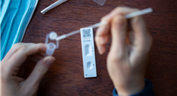 Close up of a person using coronavirus covid-19 rapid antigen home testing kit