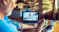 close-up of senior man consulting with his doctor online using his laptop